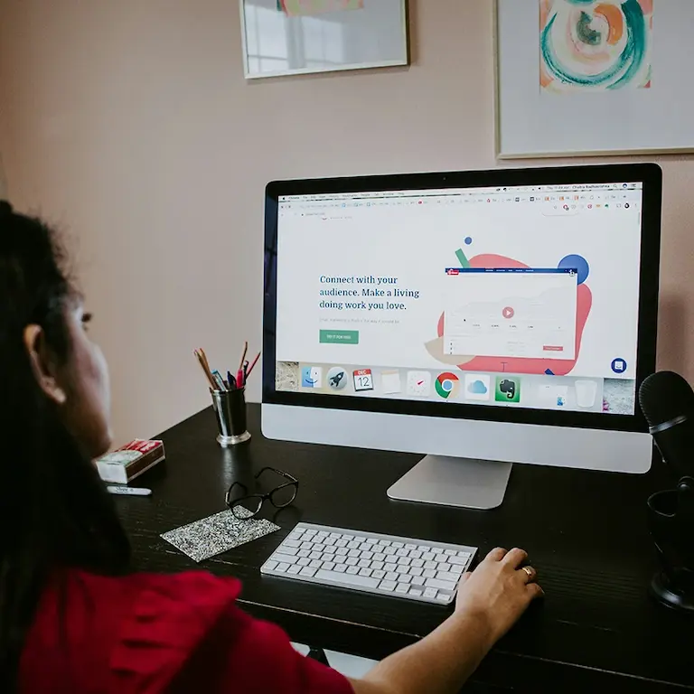 Personne concentrée travaillant sur ordinateur pour apprendre comment créer une cagnotte en ligne efficacement