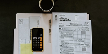 Documents fiscaux et calculatrice sur une table, symbolisant les avantages liés à un appel au don