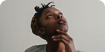 Femme pensive regardant vers le haut, illustrant la réflexion autour d’un appel au don